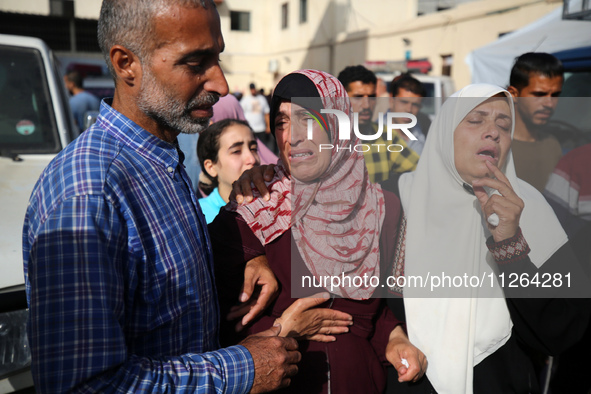 A displaced Palestinian mother is showering her child amid a heat wave inside a tent at a temporary camp in Deir el-Balah in the central Gaz...