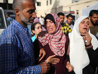 A displaced Palestinian mother is showering her child amid a heat wave inside a tent at a temporary camp in Deir el-Balah in the central Gaz...