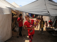 Displaced Palestinian children are playing outside their tents amid a heat wave at a temporary camp in Deir el-Balah in the central Gaza Str...