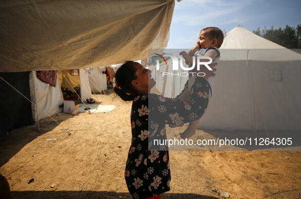 Displaced Palestinian children are playing outside their tents amid a heat wave at a temporary camp in Deir el-Balah in the central Gaza Str...