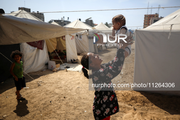 Displaced Palestinian children are playing outside their tents amid a heat wave at a temporary camp in Deir el-Balah in the central Gaza Str...