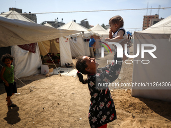 Displaced Palestinian children are playing outside their tents amid a heat wave at a temporary camp in Deir el-Balah in the central Gaza Str...