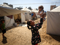 Displaced Palestinian children are playing outside their tents amid a heat wave at a temporary camp in Deir el-Balah in the central Gaza Str...