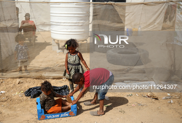 Displaced Palestinian children are playing outside their tents amid a heat wave at a temporary camp in Deir el-Balah in the central Gaza Str...