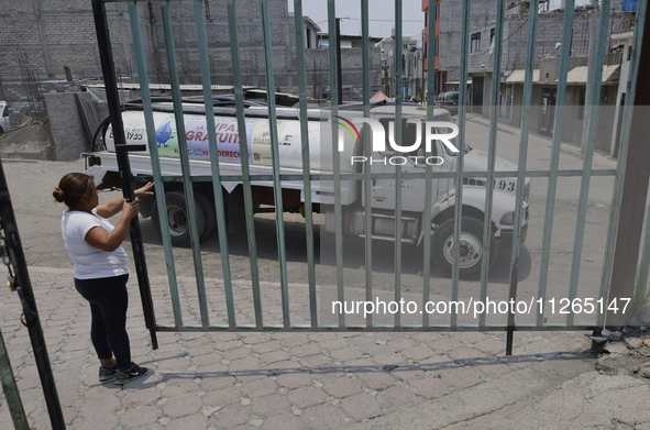 A woman is giving access to a water pipe to the property known as El Yuguelito, an irregular piece of land located in the Polvorilla Colony...