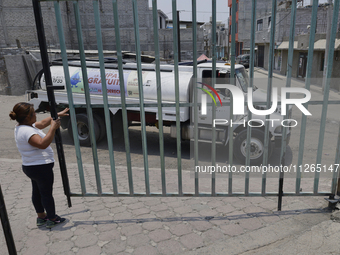 A woman is giving access to a water pipe to the property known as El Yuguelito, an irregular piece of land located in the Polvorilla Colony...