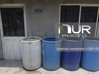 I am viewing cans to store water for homes inside the property known as El Yuguelito, an irregular piece of land located in the Polvorilla C...