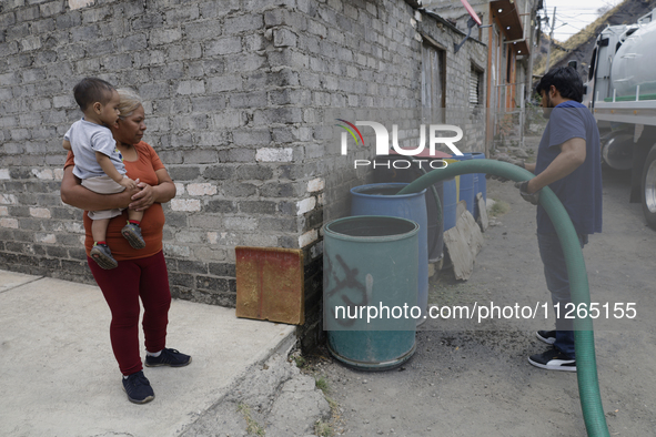 A water pipe worker is distributing water inside the property known as El Yuguelito, an irregular piece of land located in the Polvorilla Co...