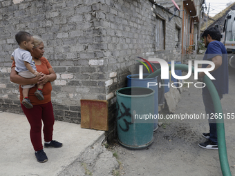 A water pipe worker is distributing water inside the property known as El Yuguelito, an irregular piece of land located in the Polvorilla Co...