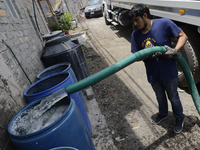 A water pipe worker is distributing water inside the property known as El Yuguelito, an irregular piece of land located in the Polvorilla Co...