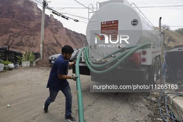 A water pipe worker is distributing water inside the property known as El Yuguelito, an irregular piece of land located in the Polvorilla Co...