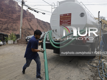 A water pipe worker is distributing water inside the property known as El Yuguelito, an irregular piece of land located in the Polvorilla Co...