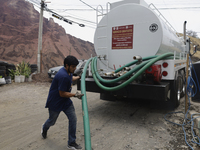 A water pipe worker is distributing water inside the property known as El Yuguelito, an irregular piece of land located in the Polvorilla Co...