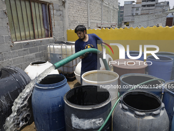 A water pipe worker is distributing water inside the property known as El Yuguelito, an irregular piece of land located in the Polvorilla Co...