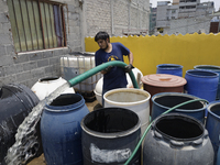 A water pipe worker is distributing water inside the property known as El Yuguelito, an irregular piece of land located in the Polvorilla Co...