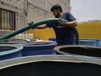 A water pipe worker is distributing water inside the property known as El Yuguelito, an irregular piece of land located in the Polvorilla Co...