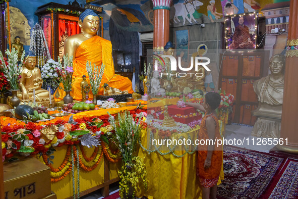 A little child is offering a lotus flower to an idol of Lord Buddha at a monastery on the occasion of Buddha Purnima in Kolkata, India, on M...