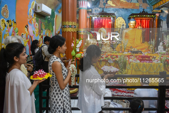 People are offering a lotus flower to an idol of Lord Buddha at a monastery on the occasion of Buddha Purnima in Kolkata, India, on May 23,...