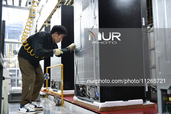 Workers are assembling refrigerators at the LG Refrigerator production base in Taizhou, China, on May 23, 2024. This is LG's largest refrige...