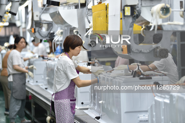 Workers are assembling refrigerators at the LG Refrigerator production base in Taizhou, China, on May 23, 2024. This is LG's largest refrige...