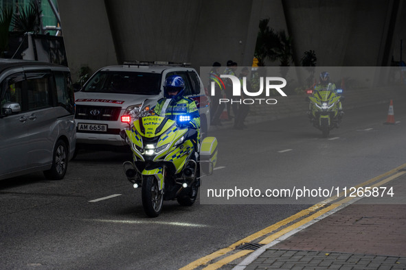 Police officers are riding motorbikes outside the courthouse where the trial of Jimmy Lai, the founder of the now-shuttered Apple Daily News...