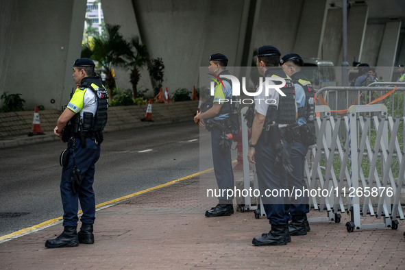 Police officers are standing guard at the courthouse where the trial of Jimmy Lai, the founder of the now-shuttered Apple Daily Newspaper, i...