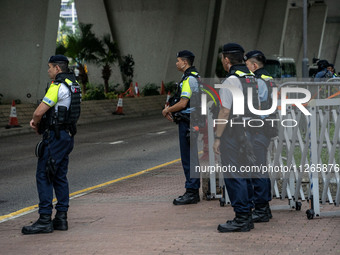 Police officers are standing guard at the courthouse where the trial of Jimmy Lai, the founder of the now-shuttered Apple Daily Newspaper, i...