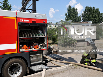 A firefighter is staying by a fire engine during a response effort to a Russian S-300 missile strike on a printing company in Kharkiv, Ukrai...