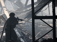 A firefighter is pouring water during a response effort to a Russian S-300 missile strike on a printing company in Kharkiv, Ukraine, on May...