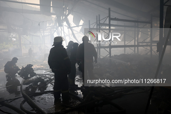 Firefighters are working during a response effort to a Russian S-300 missile strike on a printing company in Kharkiv, Ukraine, on May 23, 20...