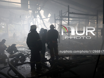 Firefighters are working during a response effort to a Russian S-300 missile strike on a printing company in Kharkiv, Ukraine, on May 23, 20...