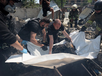 Forensic experts are working during a response effort to a Russian S-300 missile strike on a printing company in Kharkiv, Ukraine, on May 23...