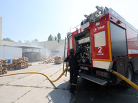 A firefighter is manning a fire engine during a response effort to a Russian S-300 missile strike on a printing company in Kharkiv, Ukraine,...