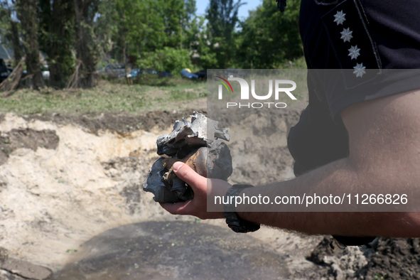 A police officer is holding the fragments of a missile during a response effort to a Russian S-300 missile strike on a printing company in K...