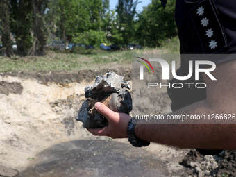 A police officer is holding the fragments of a missile during a response effort to a Russian S-300 missile strike on a printing company in K...