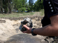 A police officer is holding the fragments of a missile during a response effort to a Russian S-300 missile strike on a printing company in K...