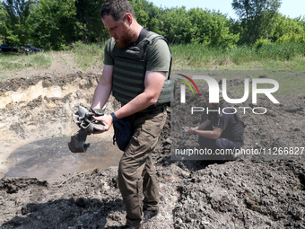 Forensic experts are working at the crater of a projectile during a response effort to a Russian S-300 missile strike on a printing company...