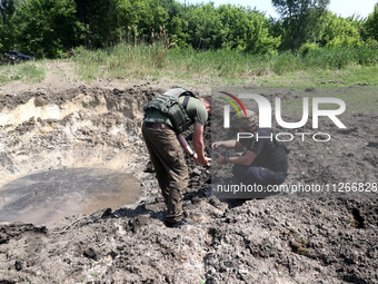 Forensic experts are working at the crater of a projectile during a response effort to a Russian S-300 missile strike on a printing company...