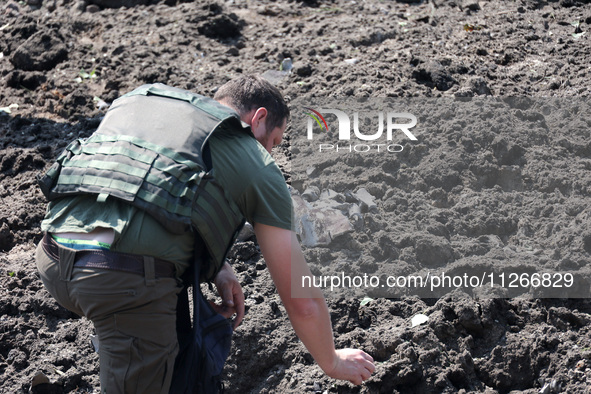 A forensic expert is working at the crater of a projectile during a response effort to a Russian S-300 missile strike on a printing company...