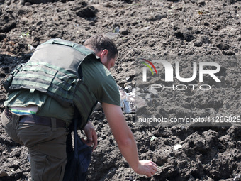 A forensic expert is working at the crater of a projectile during a response effort to a Russian S-300 missile strike on a printing company...