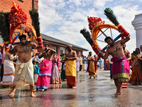 Tamil Hindu devotees are performing the Kavadi Attam dance as devotees are taking part in the chariot procession (ther) during the Ganesha M...