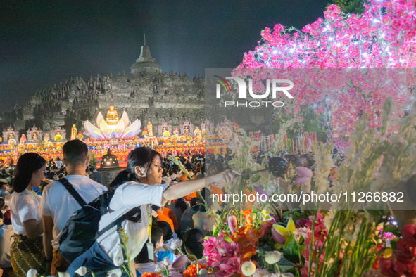 Devotees are using umbrellas for shelter during the Vesak celebration at Borobudur Temple. Despite the rainfall, their spirits are remaining...