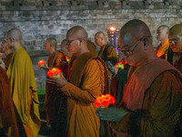 Monks are performing the Pindapata ritual, carrying lotus lamps and circling Borobudur Temple three times. (