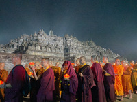 Monks are performing the Pindapata ritual, carrying lotus lamps and circling Borobudur Temple three times. (