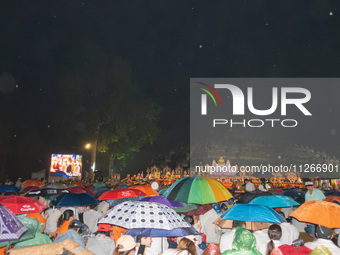 Devotees are using umbrellas for shelter during the Vesak celebration at Borobudur Temple. Despite the rainfall, their spirits are remaining...