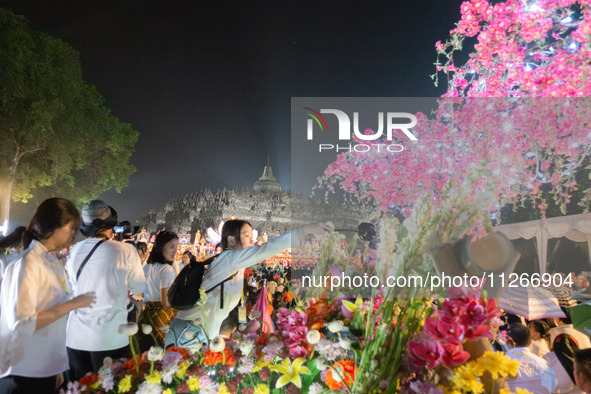 Devotees are bathing the statue of baby Siddhartha Gautama during the Vesak celebration. This ritual is signifying purification and the birt...