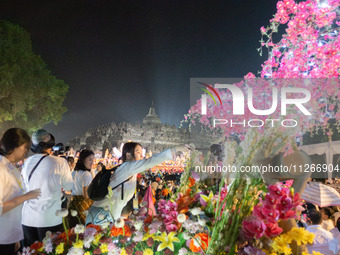 Devotees are bathing the statue of baby Siddhartha Gautama during the Vesak celebration. This ritual is signifying purification and the birt...