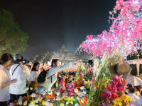 Devotees are bathing the statue of baby Siddhartha Gautama during the Vesak celebration. This ritual is signifying purification and the birt...