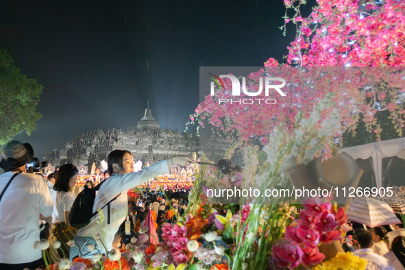 Devotees are bathing the statue of baby Siddhartha Gautama during the Vesak celebration. This ritual is signifying purification and the birt...