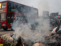 People are moving past burning garbage and plastic trash beside a busy road in Dhaka, Bangladesh, on May 23, 2024. Dhaka's air quality is be...